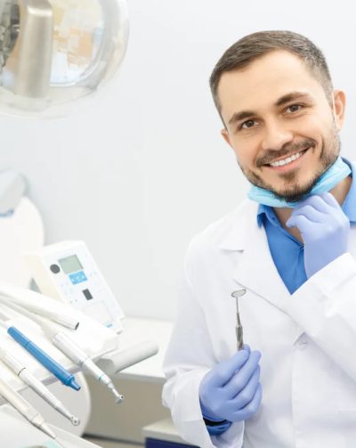 Professional,Male,Dentist,Smiling,To,The,Camera,Holding,Dental,Instruments